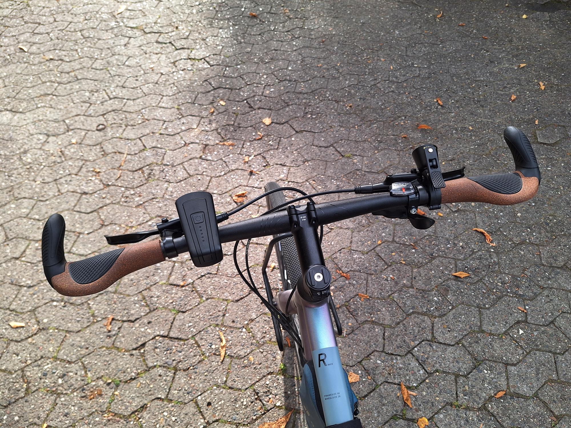 My bike handlebars with new grips and a new bell AI generated caption: Bicycle handlebars with grips and mounted devices.